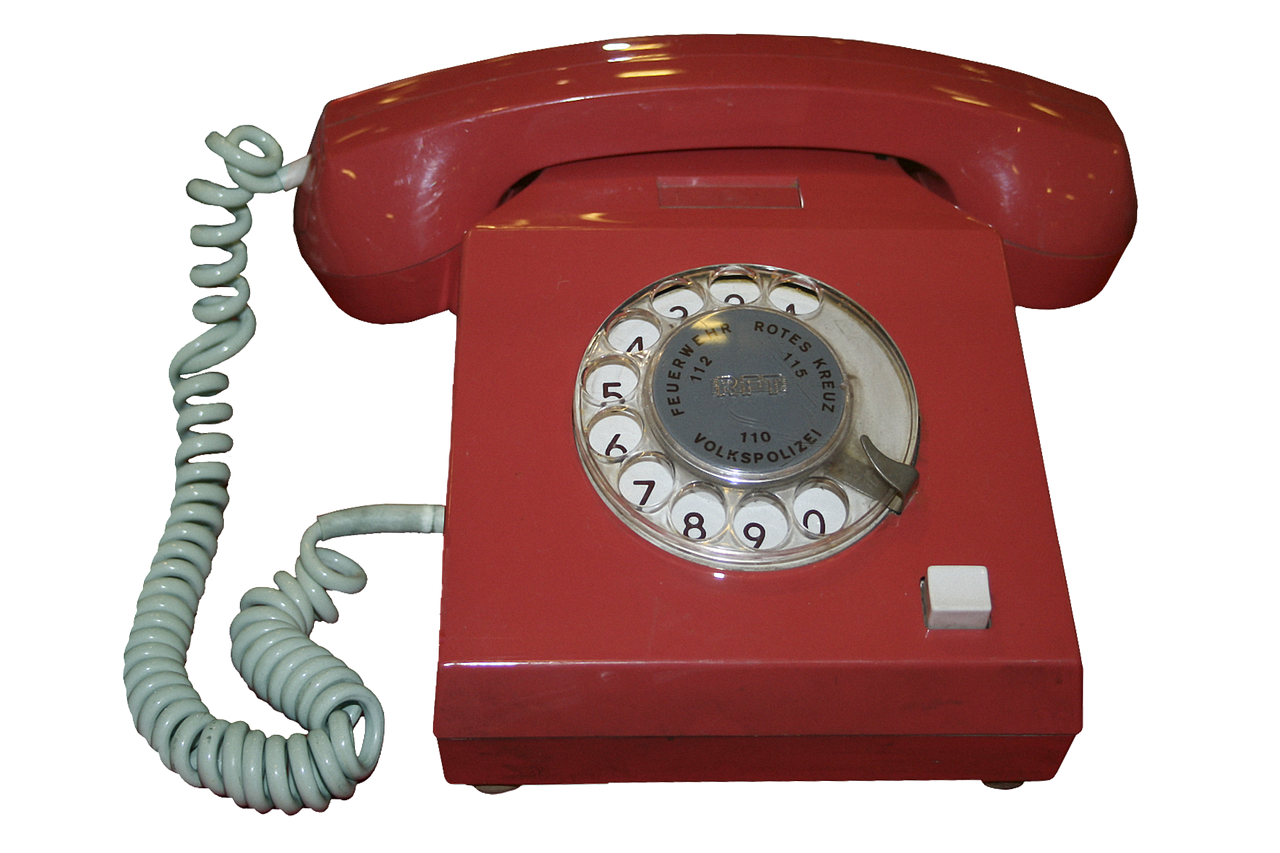 A photo of an old red rotary phone. its a link that leads to the about page.